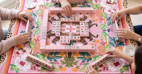 Pile of pink and white mahjong tiles on a black surface, with the white